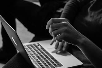 grayscale photo of person using MacBook