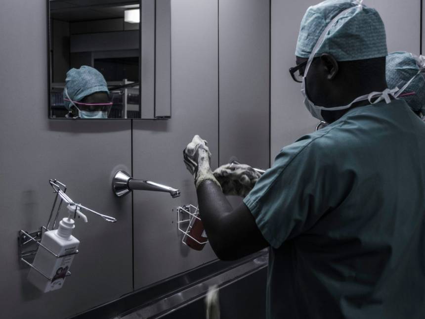 man wearing surgical suit near mirror