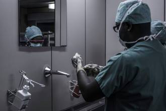 man wearing surgical suit near mirror