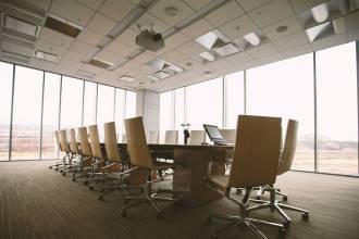 oval brown wooden conference table and chairs inside conference room